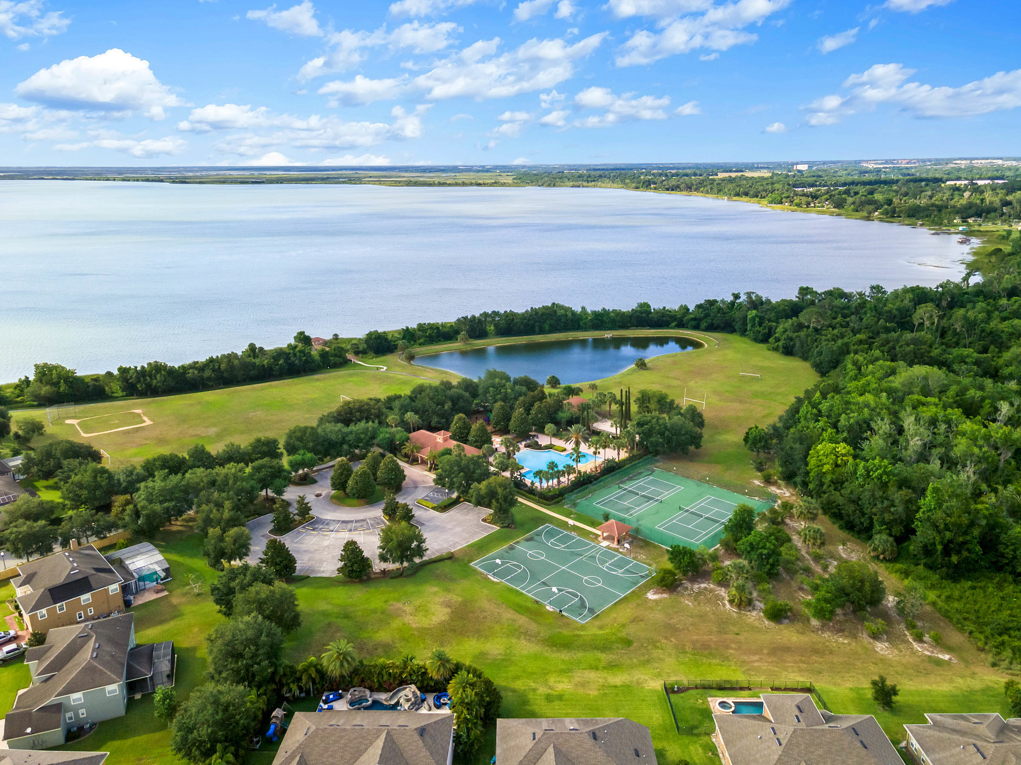 drone shot of lake and community clubhouse with houses